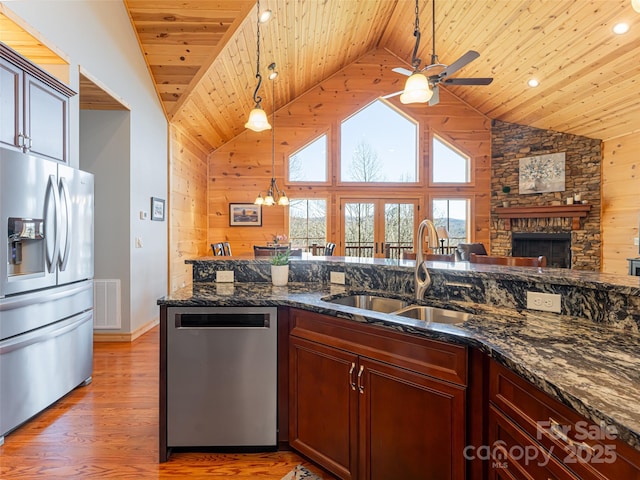 kitchen featuring appliances with stainless steel finishes, sink, dark stone counters, and wood ceiling