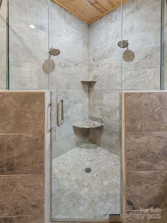 bathroom with wood ceiling and a shower with shower door