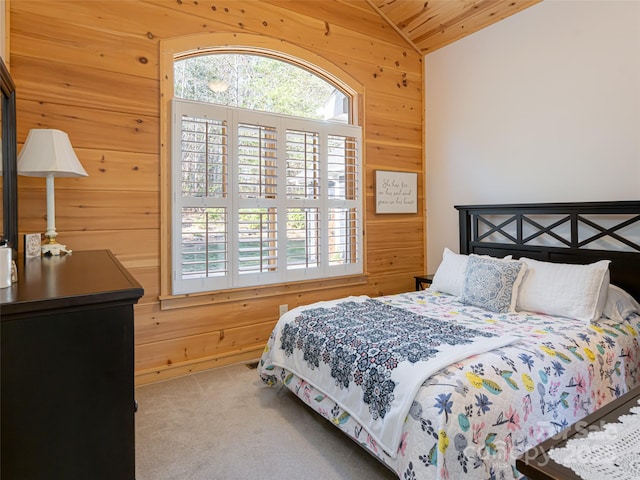 bedroom featuring carpet flooring, vaulted ceiling, wooden ceiling, and wood walls