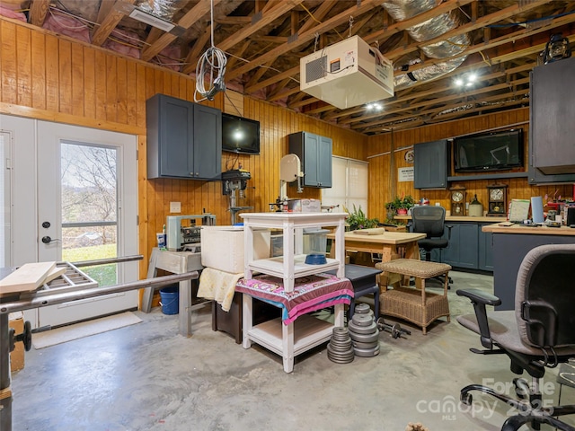 interior space with baseboard heating, a workshop area, and wood walls