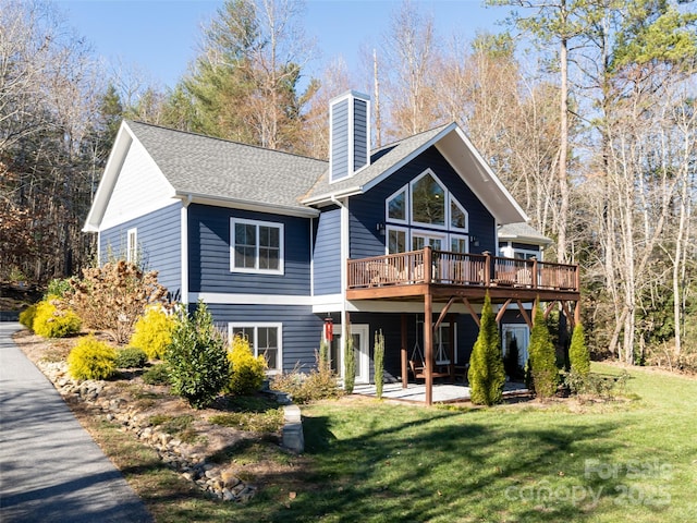 rear view of property with a yard and a wooden deck