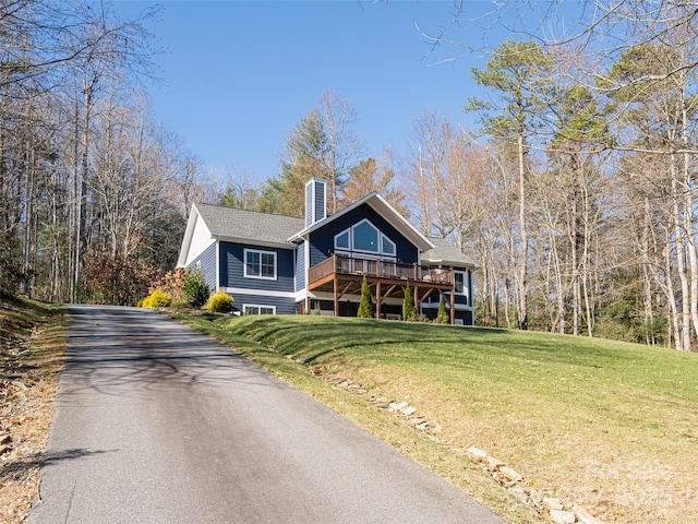 view of property with a wooden deck and a front yard