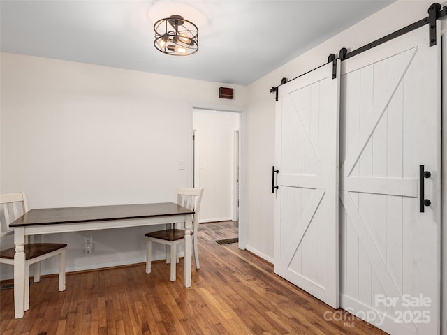 unfurnished dining area with hardwood / wood-style floors and a barn door