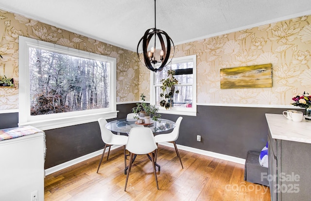 dining room with baseboards, hardwood / wood-style floors, a wealth of natural light, and wallpapered walls