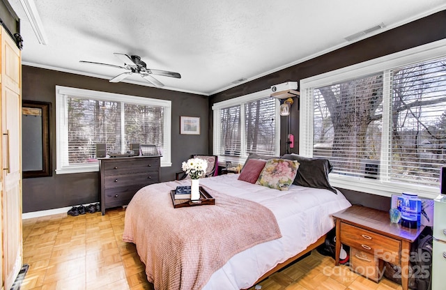 bedroom featuring baseboards, visible vents, ceiling fan, ornamental molding, and a textured ceiling