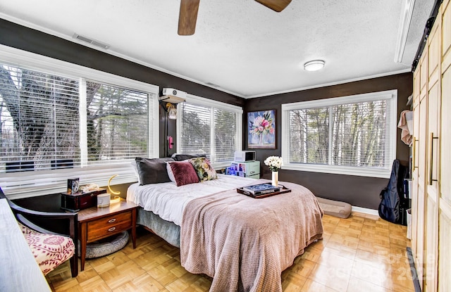 bedroom featuring a textured ceiling, a ceiling fan, visible vents, and baseboards