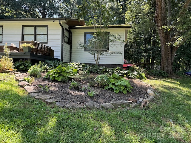 view of side of property with a wooden deck and a yard