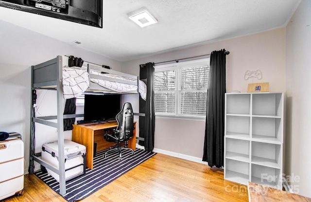 bedroom with baseboards and wood finished floors