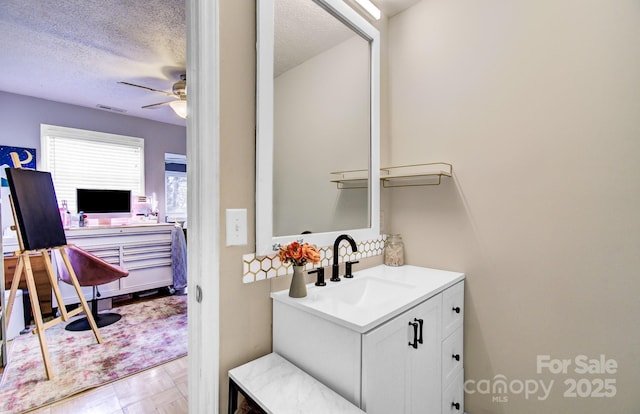 bathroom with ceiling fan, visible vents, a textured ceiling, and vanity