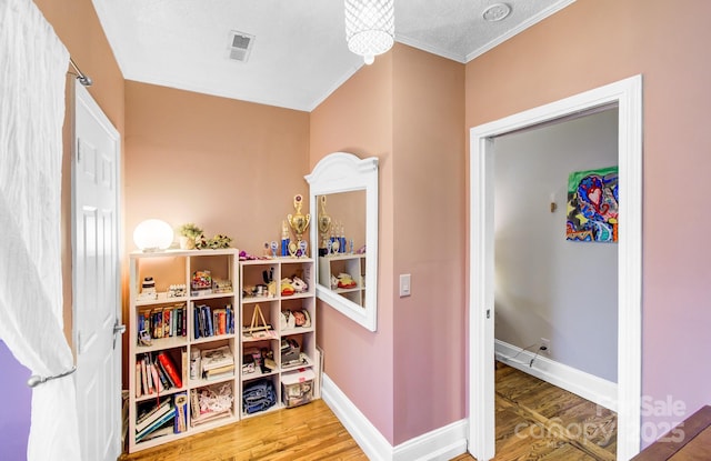 rec room featuring wood finished floors, visible vents, and baseboards