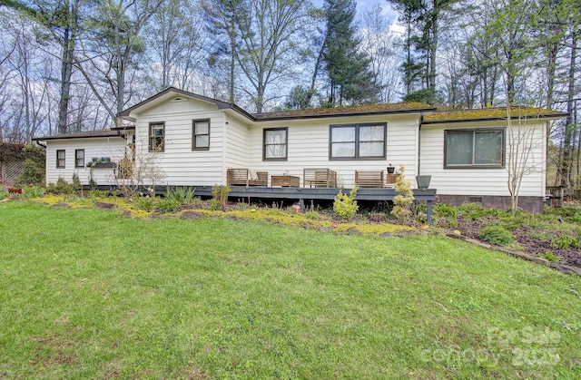 rear view of property featuring a yard and a deck