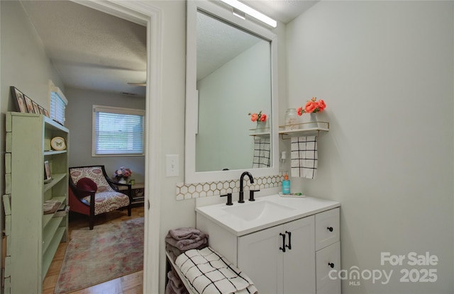 6 Candor Dr, Fletcher, NC 28732 - bathroom with decorative backsplash, vanity, a textured ceiling, and wood finished floors