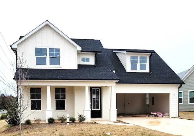 modern farmhouse style home with a porch, roof with shingles, board and batten siding, and concrete driveway