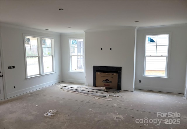 unfurnished living room with baseboards, ornamental molding, and a fireplace