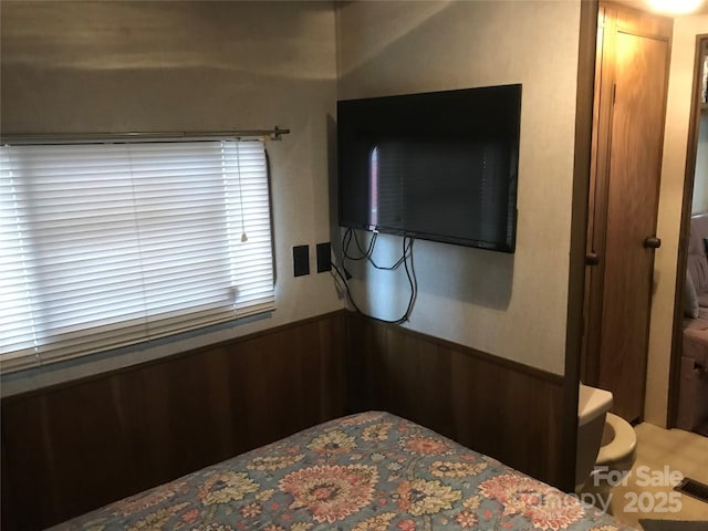 bedroom featuring wooden walls