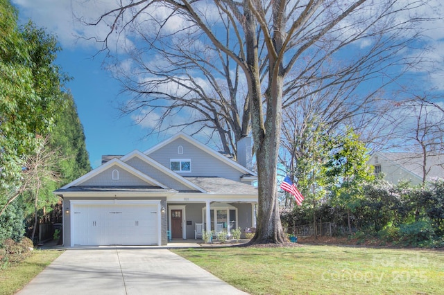 view of front of home featuring covered porch, a garage, and a front lawn