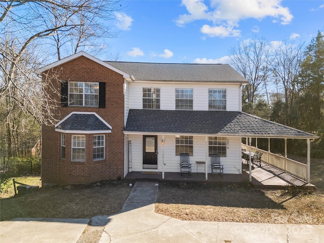 view of front of home featuring a porch, brick siding, and a shingled roof