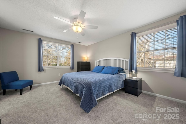 carpeted bedroom featuring visible vents, ceiling fan, a textured ceiling, and baseboards