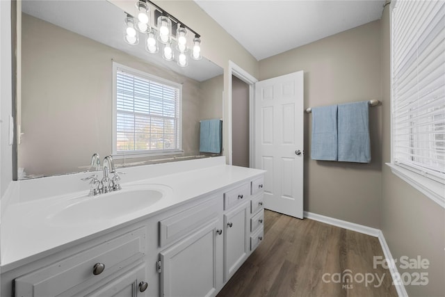 bathroom with vanity, wood finished floors, and baseboards