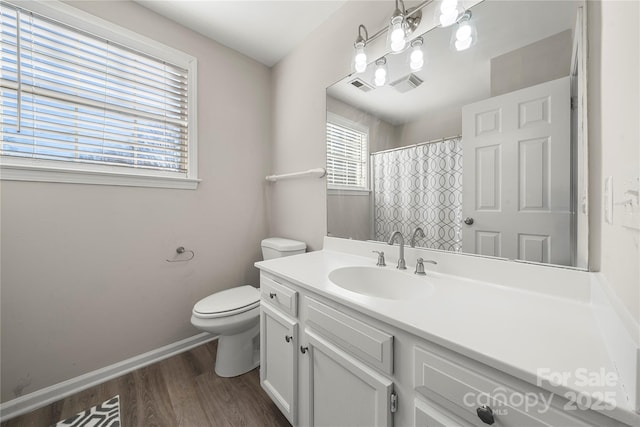 bathroom featuring vanity, wood finished floors, visible vents, baseboards, and toilet