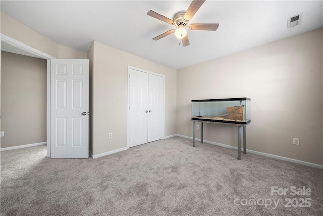 unfurnished bedroom featuring visible vents, a closet, carpet floors, baseboards, and ceiling fan