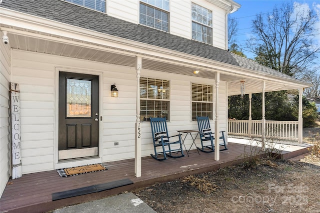 property entrance featuring roof with shingles and a porch