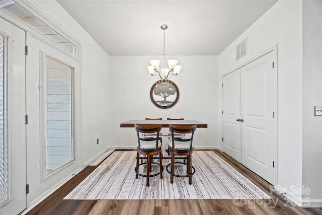 dining area featuring a notable chandelier and wood-type flooring