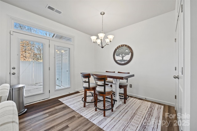 dining space featuring a chandelier and dark hardwood / wood-style floors