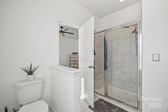 bathroom with ceiling fan, a shower with shower door, and toilet