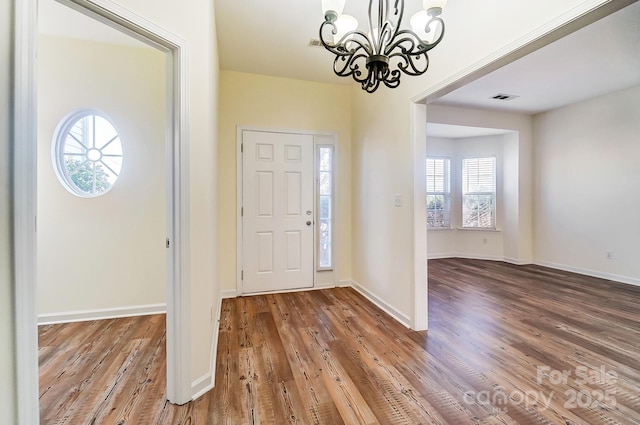 entrance foyer with wood-type flooring and a notable chandelier