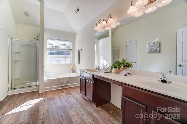 bathroom featuring hardwood / wood-style floors, vanity, shower with separate bathtub, and vaulted ceiling