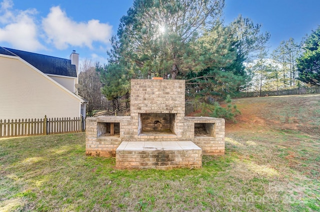 view of yard featuring an outdoor brick fireplace