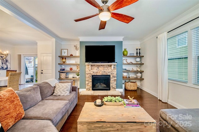 living room with crown molding, a stone fireplace, ceiling fan, and dark hardwood / wood-style flooring