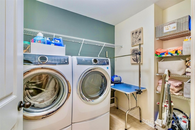 laundry room featuring washer and clothes dryer and light tile patterned flooring