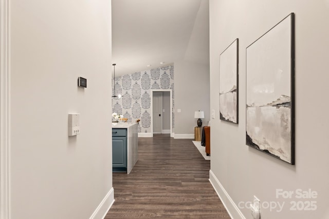 corridor with dark hardwood / wood-style flooring and vaulted ceiling