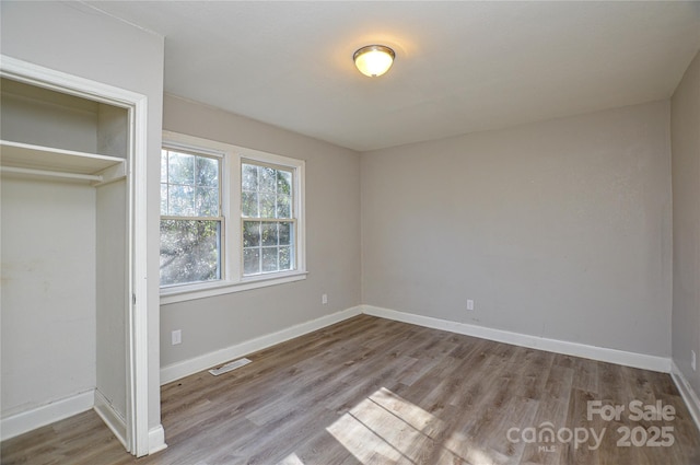 unfurnished bedroom featuring a closet and light wood-type flooring