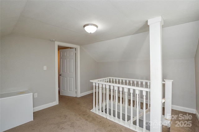 interior space featuring light colored carpet, vaulted ceiling, and a nursery area