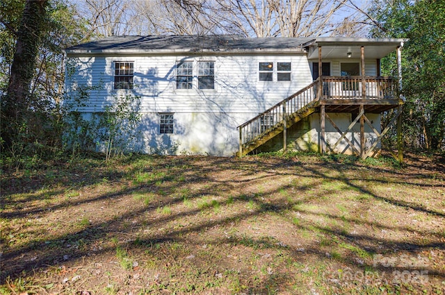 rear view of house with a lawn and a deck