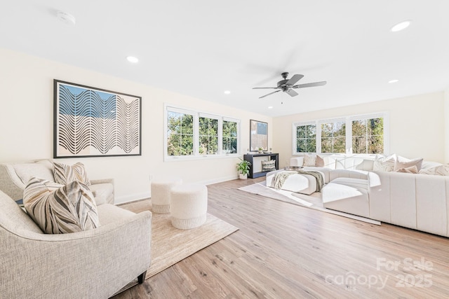 living room with ceiling fan, a healthy amount of sunlight, and light hardwood / wood-style flooring