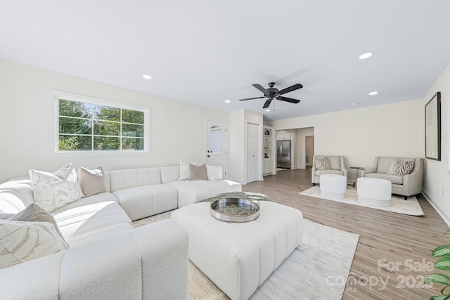 living room featuring ceiling fan and light hardwood / wood-style flooring