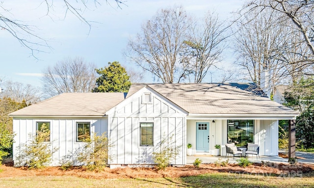 711 Concord Rd, Davidson, NC 28036 - view of front of house with board and batten siding, covered porch, and roof with shingles