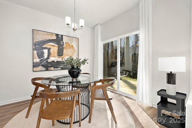 dining space featuring a notable chandelier, wood-type flooring, and plenty of natural light