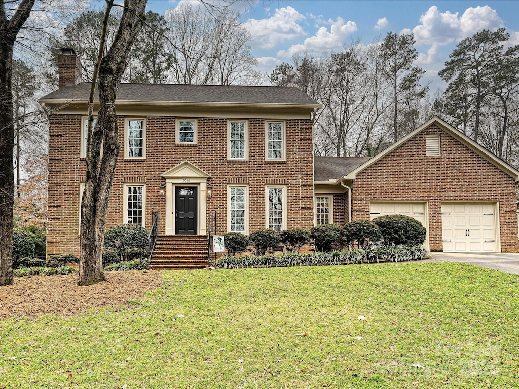 view of front of home with a front yard and a garage