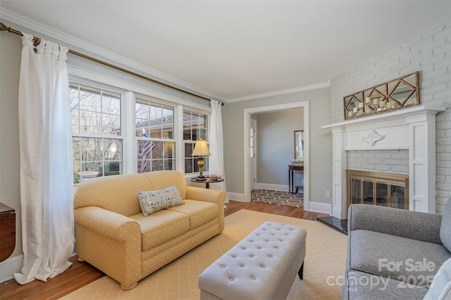 living room with wood-type flooring, crown molding, and a fireplace