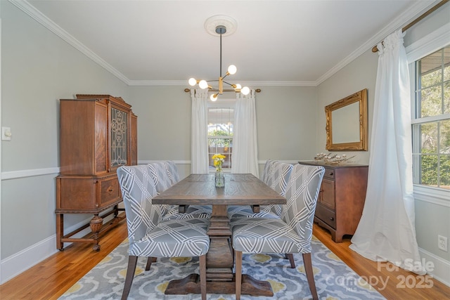 dining space with an inviting chandelier, hardwood / wood-style flooring, and ornamental molding