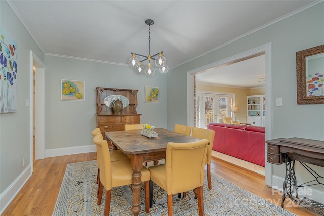 dining room featuring ornamental molding, a chandelier, and light hardwood / wood-style flooring