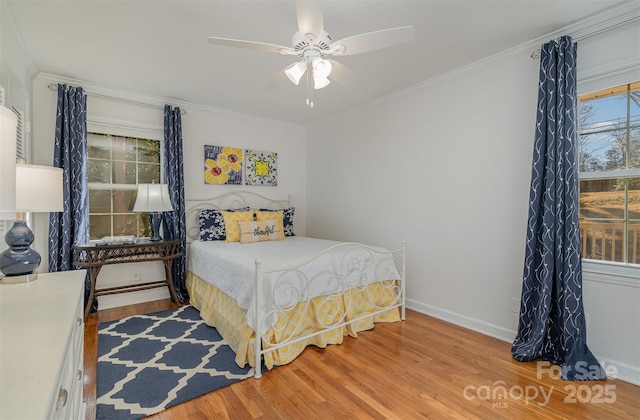 bedroom with ornamental molding, ceiling fan, and light hardwood / wood-style floors