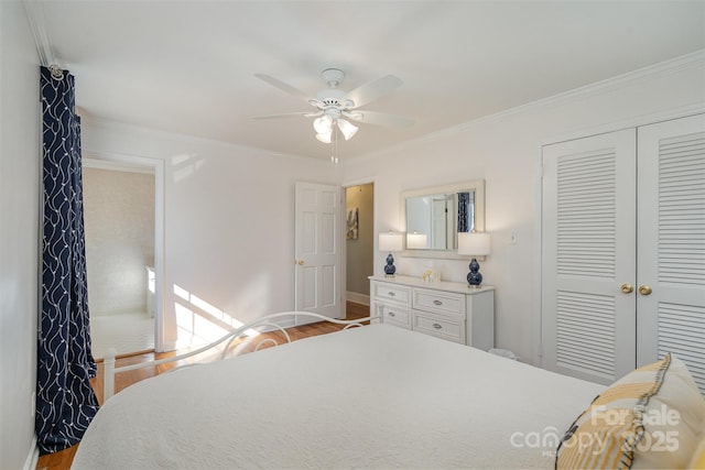 bedroom featuring crown molding, ceiling fan, light wood-type flooring, and a closet