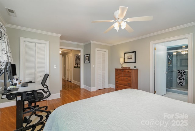 bedroom featuring ceiling fan, ornamental molding, light hardwood / wood-style floors, and two closets