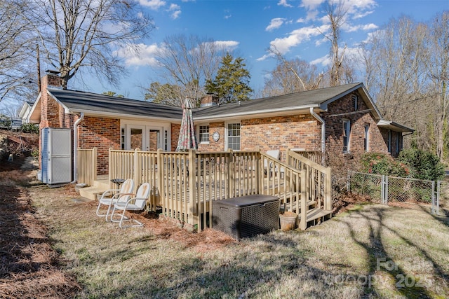 back of house with a wooden deck, a yard, and french doors